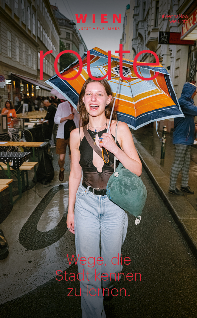 Cover der Broschüre route, das eine junge Dame mit Regenschirm zeigt. 