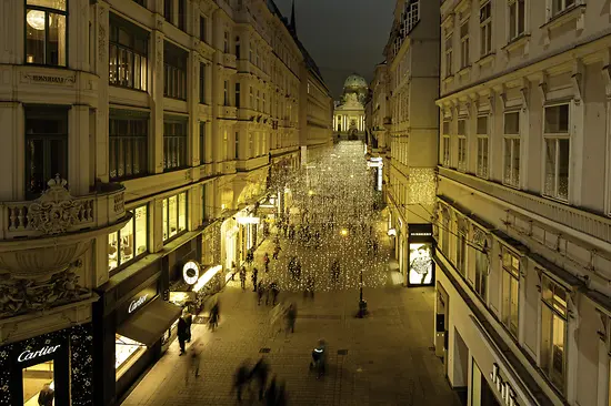 People taking an evening stroll on the atmospherically lit Kohlmarkt