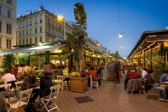 Buntes Treiben in den Lokalen am Naschmarkt, Außenansicht mit Leuten 