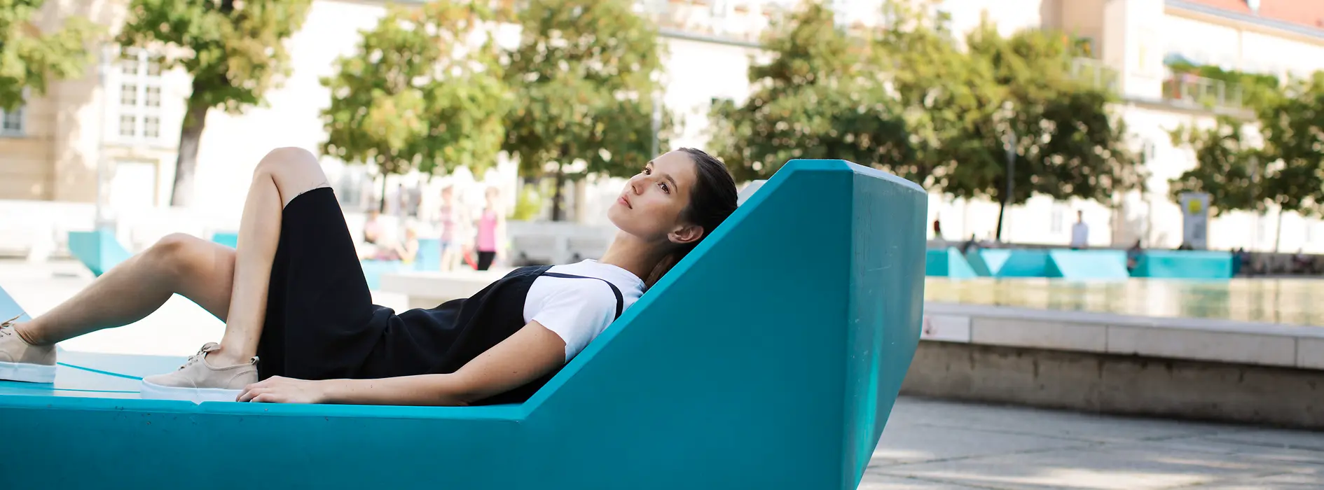 Woman lying on outdoor furniture in the inner courtyard of the MuseumsQuartier