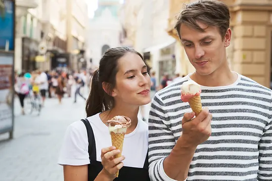 Pareja tomando helado mientras pasea por el casco antiguo