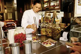 Una mujer preparando salchichas