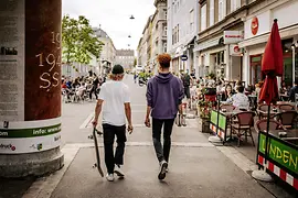 Menschen sitzen in Gastgärten