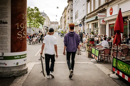 Menschen sitzen in Gastgärten