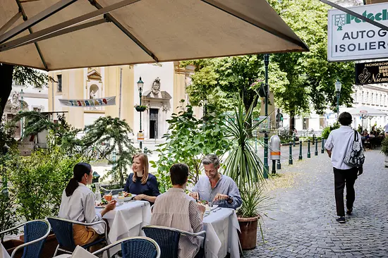 Menschen sitzen in einem Gastgarten