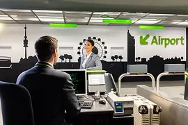 Young lady in a grey suit at the check-in counter at City Airport Terminal