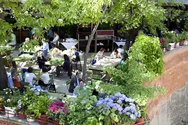 Zahrada v Glacis Beisl, lidé na obědě