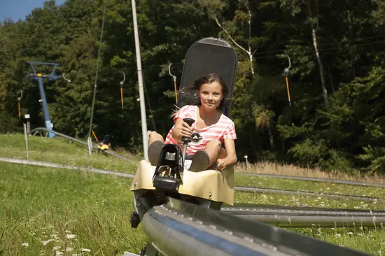 Mädchen auf der Sommerrodelbahn