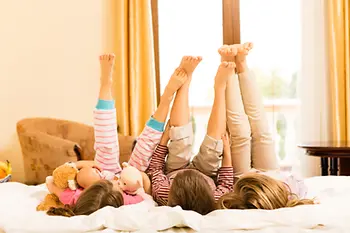 Kinder liegen auf Hotelbett