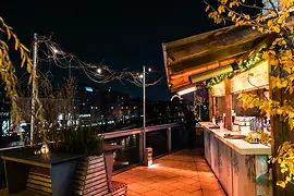 Gente bebiendo ponche en una terraza con vista sobre el Canal del Danubio