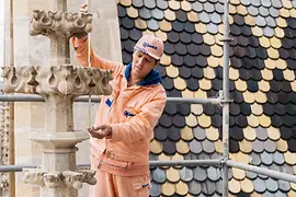 Operaio sul tetto del duomo di Santo Stefano con tuta da lavoro rosa Manner 