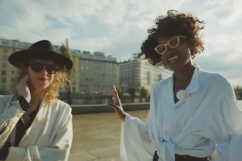 Two women in stylish outfit on the banks of the Danube Canal