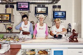 Three elderly ladies behind the coffee house counter