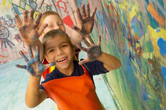 Two boys with hands full of colour