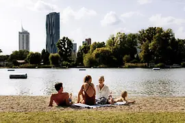 Strandbad Gänsehäufel an der Alten Donau: Ein Mann, zwei Frauen und ein Kind am Strand