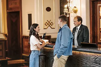 Recepcja hotelu: goście i recepcjonista