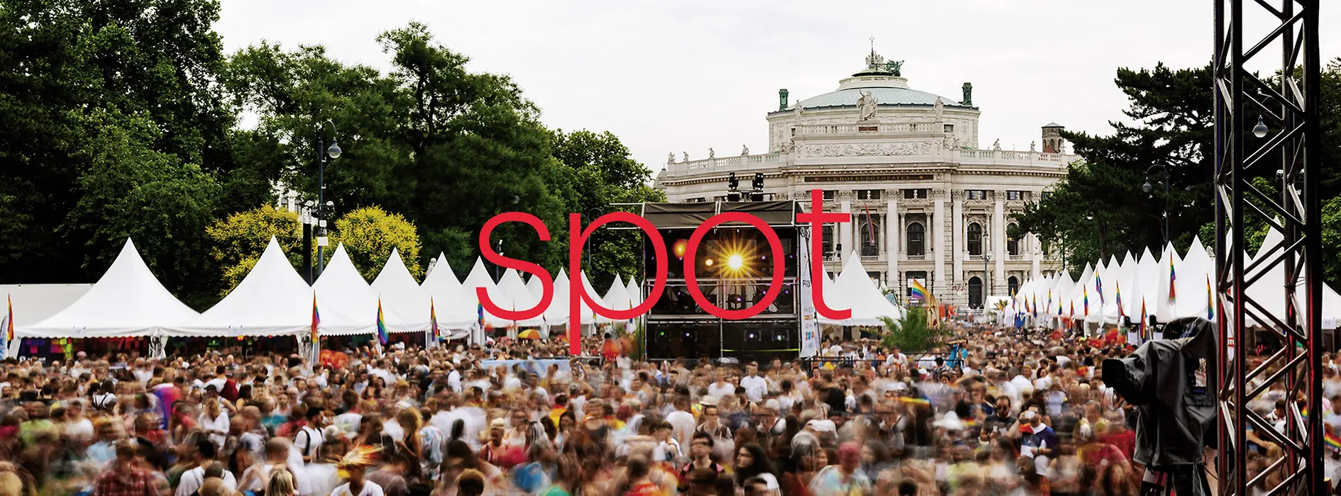 Al centro dell'immagine è scritto a grandi lettere rosse il nome della brochure dell'evento; l'immagine mostra un evento davanti al Burgtheater.
