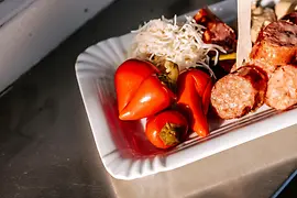 Sliced sausage with pepperoni on a paper plate