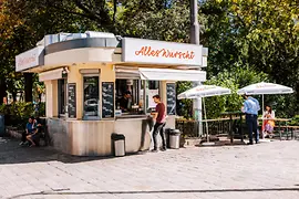 Clientes frente a un puesto de salchichas con sombrillas