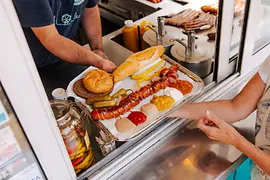 A cut sausage is handed over the counter