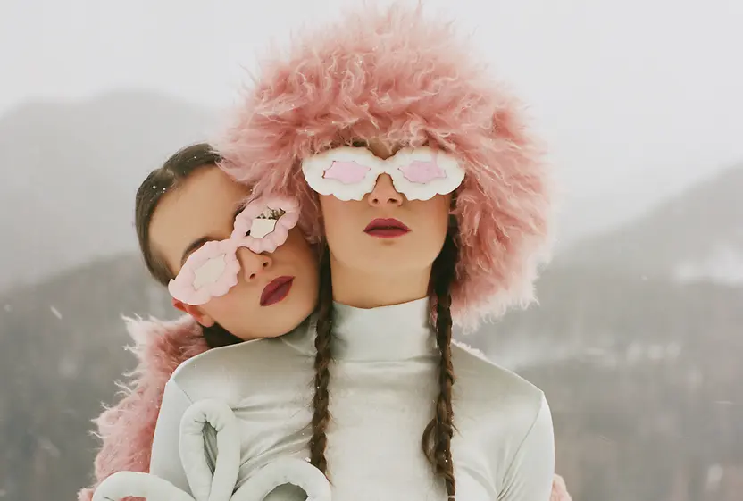 Two female models in front of a mountain landscape in the snow