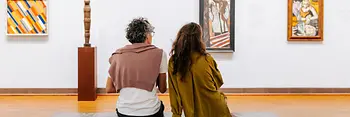 Visita al museo Albertina, dos personas sentadas en un banco mirando arte