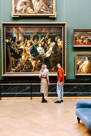 Kunsthistorisches Museum in Vienna. A man and a woman look at paintings from the Baroque period.