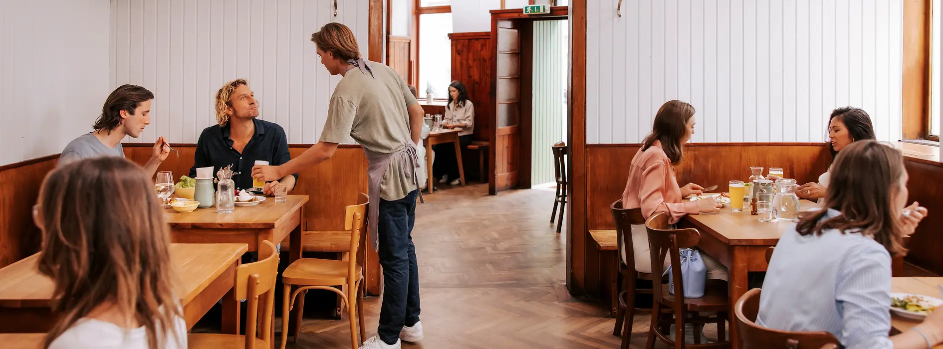 Vedere din interior a restaurantului Brösl din cartierul Stuwerviertel, oaspeții fiind serviți