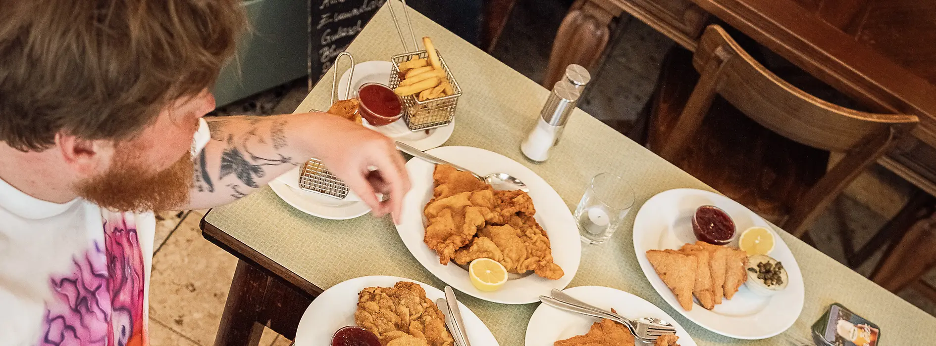 Two people at a table with numerous Wiener schnitzels