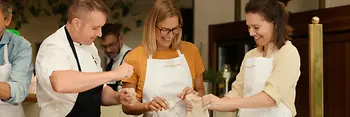 People preparing a Wiener Schnitzel