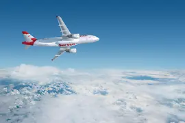 Fehér repülőgép az Austrian Airlines piros színű „Servus” feliratával a felhők fölött