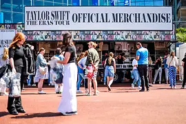 Merchandise stand at a Taylor Swift concert with fans in front of it