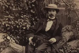 Photographie de Johann Strauss fils, assis sur un tronc d'arbre. Photographe : Carl Heberth, vers 1865