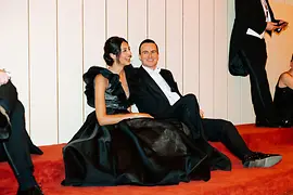 Couple in ball attire sitting on the floor and recovering from dancing