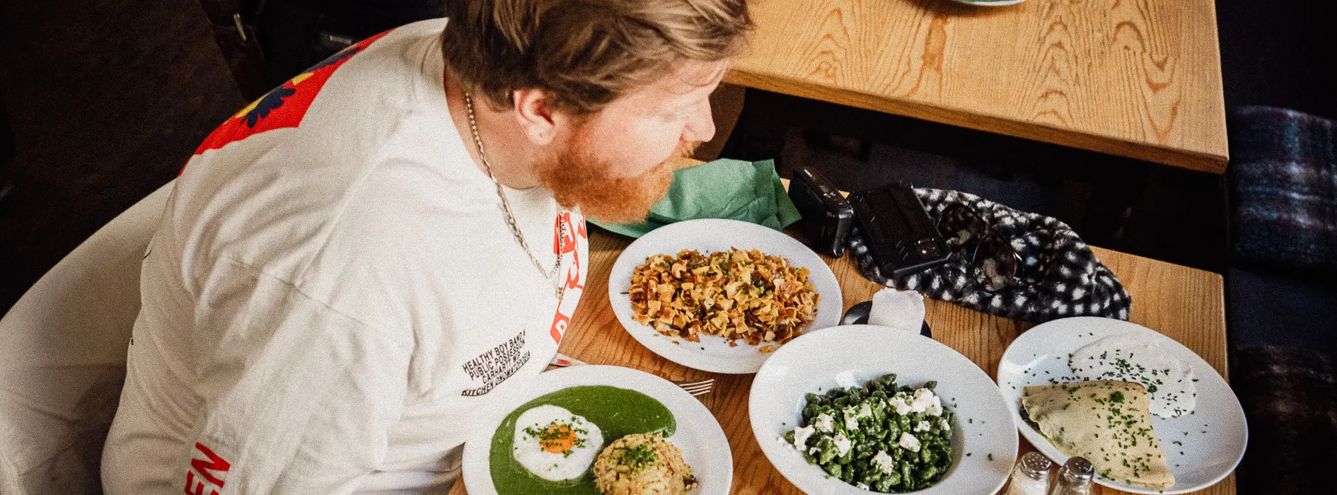 Chef Lukas Mraz in front of a crowd of plates of vegetarian dishes