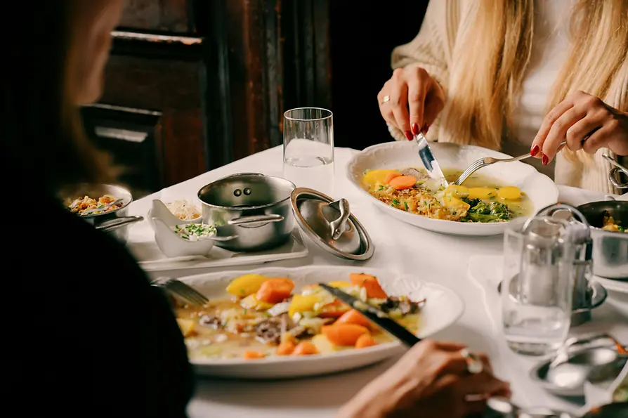 Frauen essen Tafelspitz an einem schön gedeckten Tisch