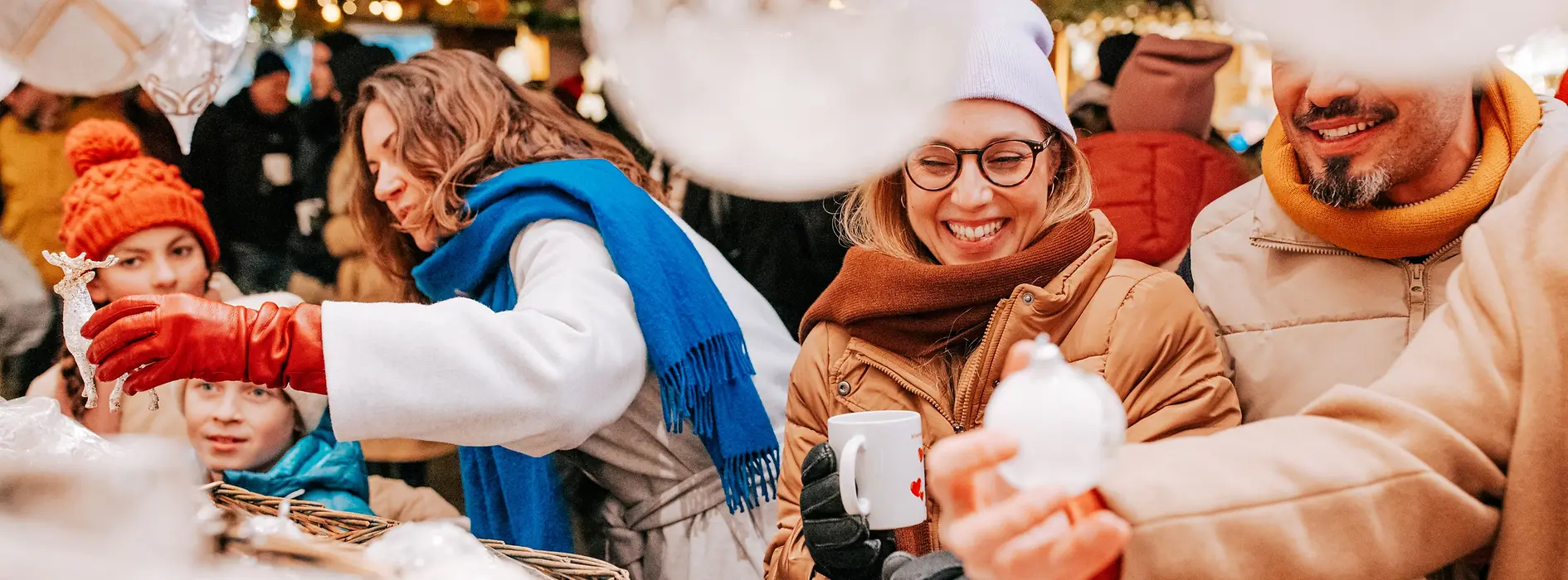 Menschengruppe bei einem Stand am Weihnachtsmarkt